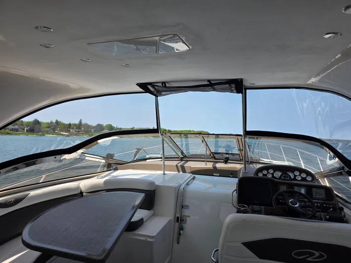  Yacht Photos Pics 2005 Regal Commodore 4260 yacht interior with helm and seating, overlooking serene water.