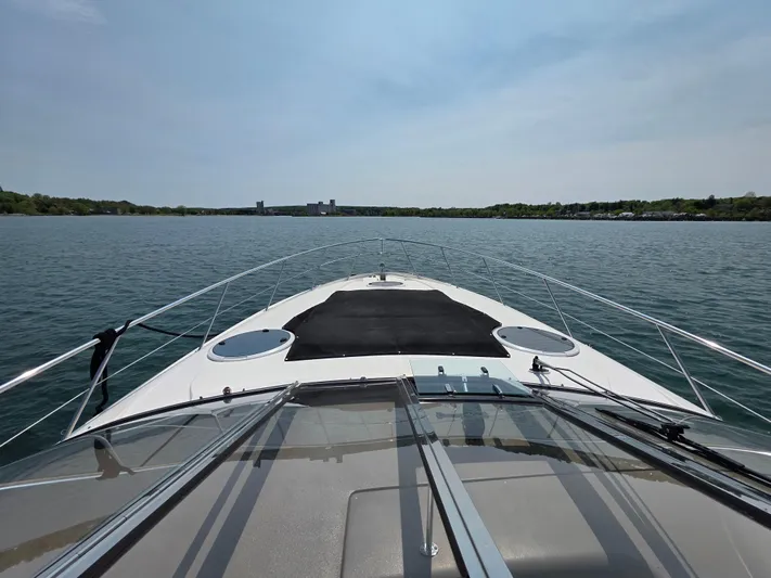  Yacht Photos Pics 2005 Regal Commodore 4260 yacht cruising on a calm lake under a clear sky.