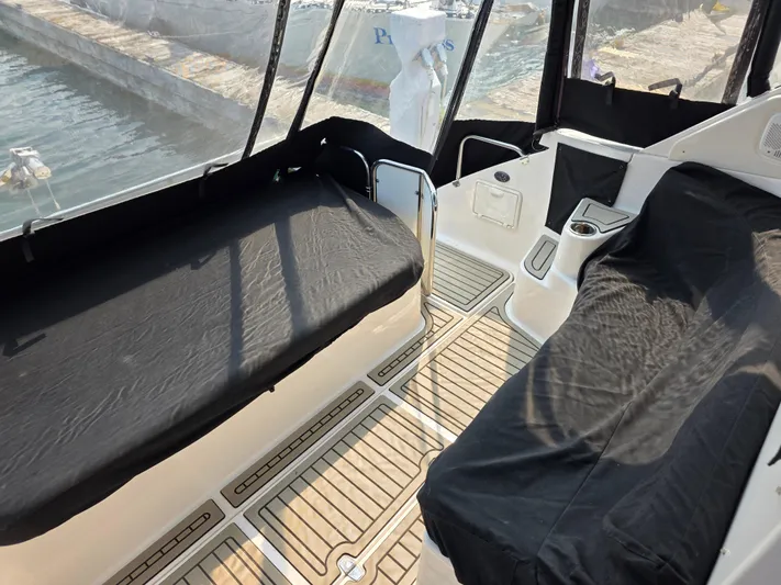  Yacht Photos Pics 2005 Regal Commodore 4260 boat interior with black seat covers and wooden flooring.