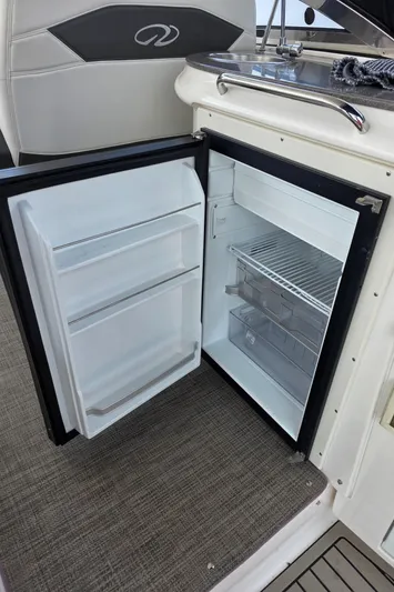  Yacht Photos Pics Open mini fridge on 2005 Regal Commodore 4260 boat, showing interior shelves and storage.