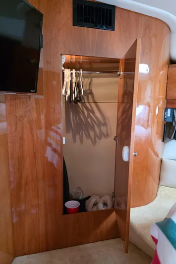  Yacht Photos Pics 2005 Regal Commodore 4260 interior with open wooden closet and hangers.