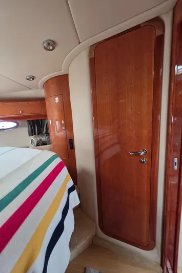  Yacht Photos Pics Interior of 2005 Regal Commodore 4260 yacht with wooden door and striped blanket.
