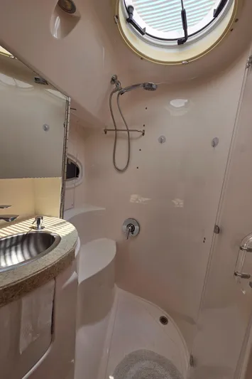  Yacht Photos Pics 2005 Regal Commodore 4260 yacht bathroom with shower, sink, and porthole window.