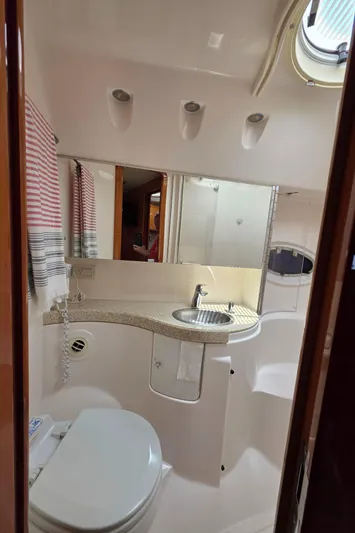  Yacht Photos Pics 2005 Regal Commodore 4260 yacht bathroom with modern fixtures and porthole window.