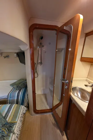  Yacht Photos Pics 2005 Regal Commodore 4260 yacht interior with compact bathroom and cozy sleeping area.