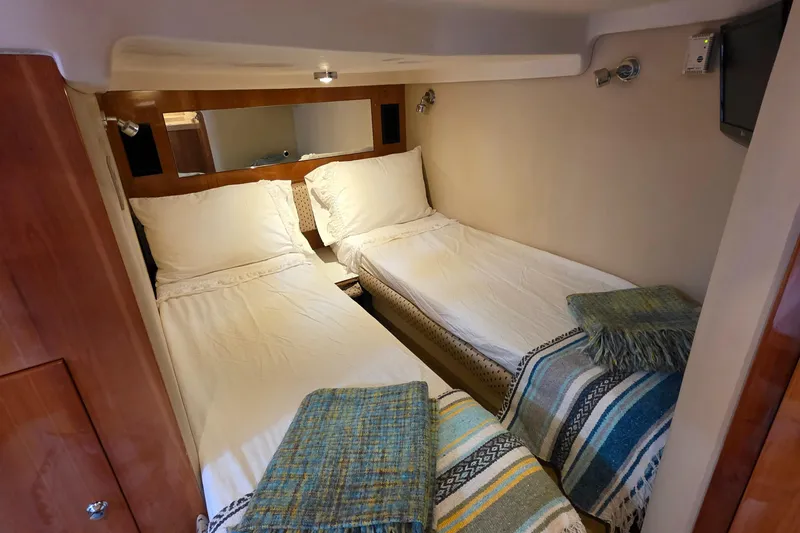  Yacht Photos Pics Twin cabin beds in 2005 Regal Commodore 4260 yacht, featuring cozy bedding and ambient lighting.