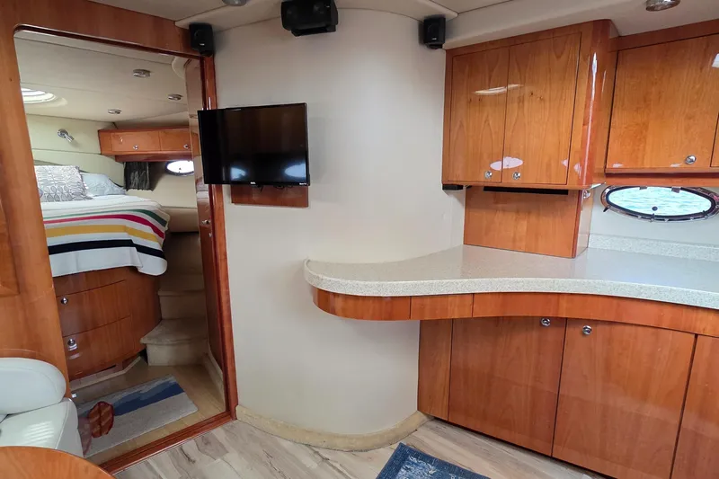  Yacht Photos Pics 2005 Regal Commodore 4260 interior with wood cabinetry, TV, and cozy bedroom.