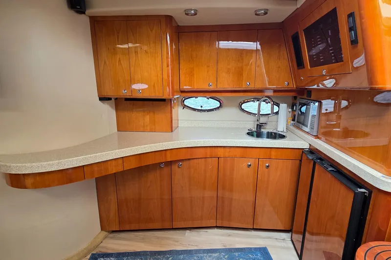  Yacht Photos Pics 2005 Regal Commodore 4260 yacht kitchen with wooden cabinets, sink, and appliances.