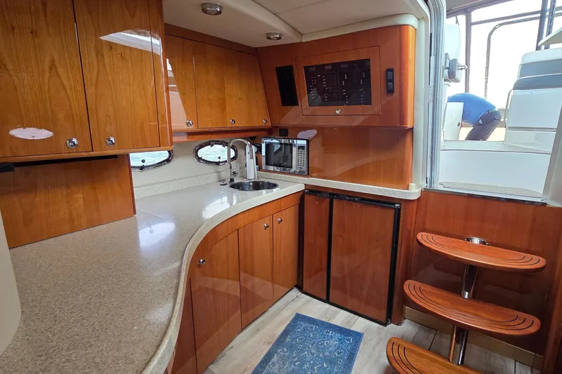  Yacht Photos Pics 2005 Regal Commodore 4260 yacht kitchen with wooden cabinets and modern appliances.