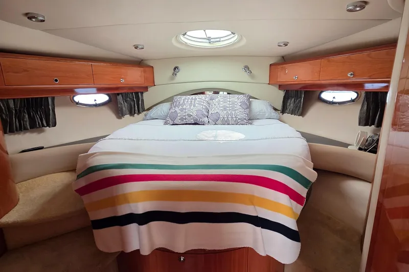  Yacht Photos Pics Luxurious cabin interior of 2005 Regal Commodore 4260 yacht with cozy bed and striped blanket.