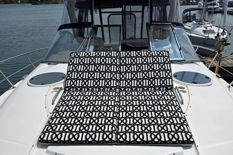  Yacht Photos Pics 2005 Regal Commodore 4260 yacht with patterned sunbed on deck, docked at marina.