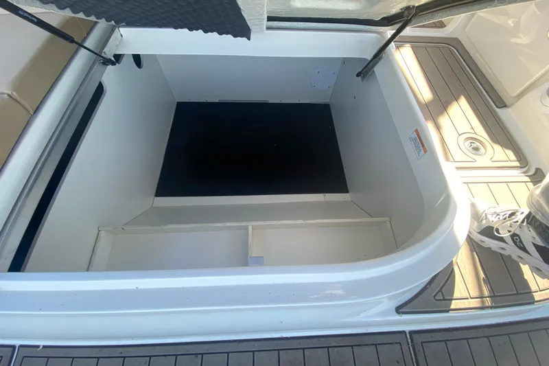  Yacht Photos Pics 2022 Sea Ray SDX 270 Outboard storage compartment, open and empty, with deck flooring visible.