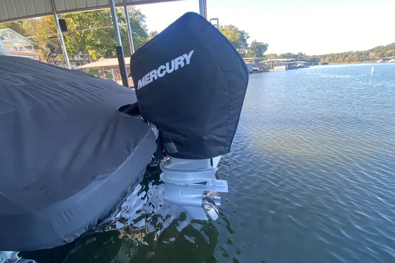  Yacht Photos Pics 2022 Sea Ray SDX 270 Outboard with Mercury engine cover, docked on a calm lake.