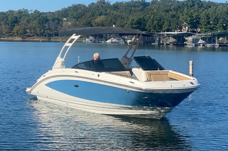  Yacht Photos Pics 2022 Sea Ray SDX 270 Outboard boat on a calm lake with trees in the background.