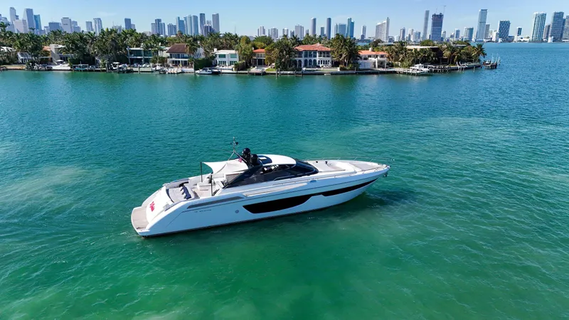  Yacht Photos Pics 2018 Riva 76' Bahamas yacht cruising near a city skyline and waterfront homes.