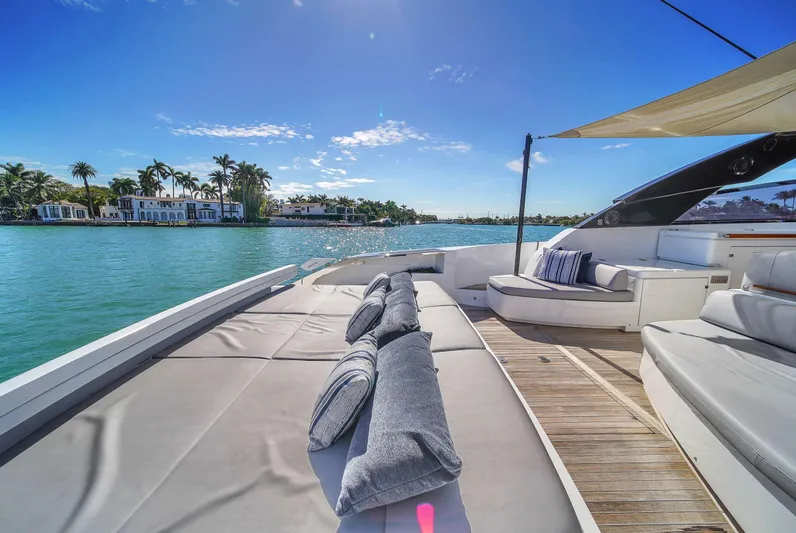  Yacht Photos Pics Luxurious 2018 Riva 76' Bahamas yacht with sun deck, cushions, and scenic waterfront view.