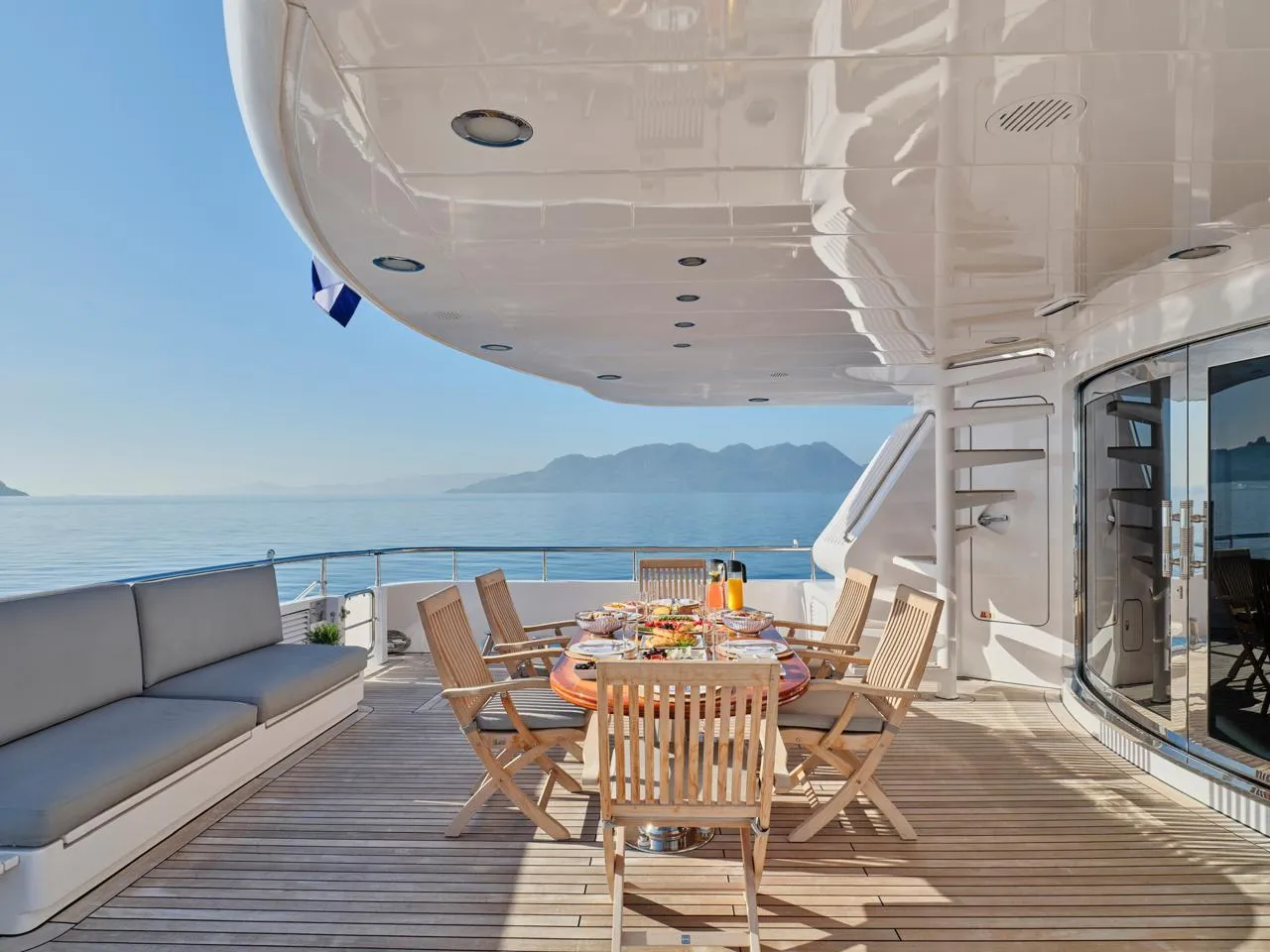 Luxurious Codecasa 115 yacht deck with dining area, ocean view, and elegant seating, built in 2000.