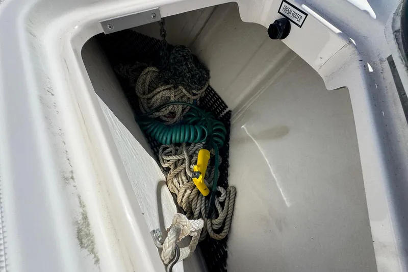 Lone Star Yacht Photos Pics Storage compartment on a 2005 Tiara Yachts 3200 Open, containing ropes and a hose.