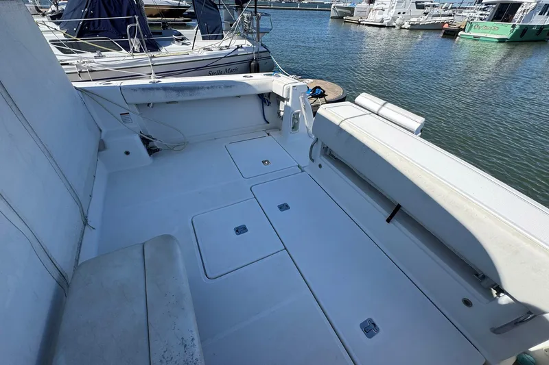 Lone Star Yacht Photos Pics 2005 Tiara Yachts 3200 Open boat deck, featuring spacious seating and storage, docked at marina.