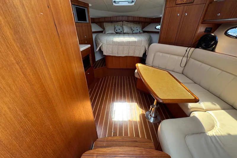 Lone Star Yacht Photos Pics 2005 Tiara Yachts 3200 Open interior with wood finish, cozy seating, and a bed.