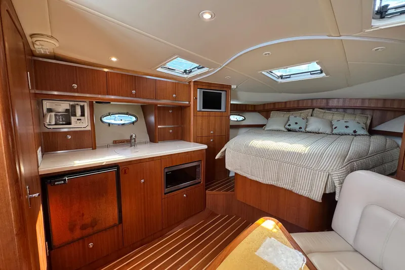 Lone Star Yacht Photos Pics Luxurious interior of 2005 Tiara Yachts 3200 Open with cozy bed and kitchenette.