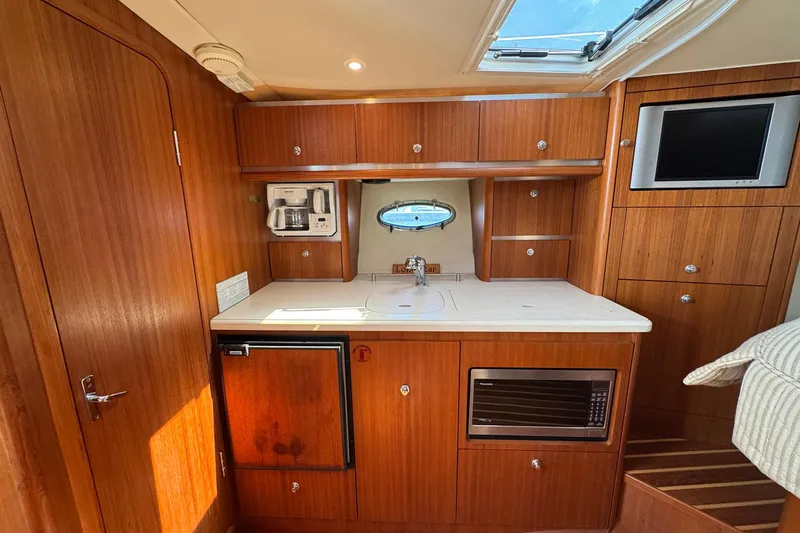 Lone Star Yacht Photos Pics 2005 Tiara Yachts 3200 Open interior kitchen with wood cabinetry and modern appliances.