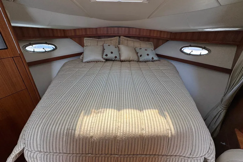 Lone Star Yacht Photos Pics Luxurious cabin interior of 2005 Tiara Yachts 3200 Open with cozy bed and porthole windows.