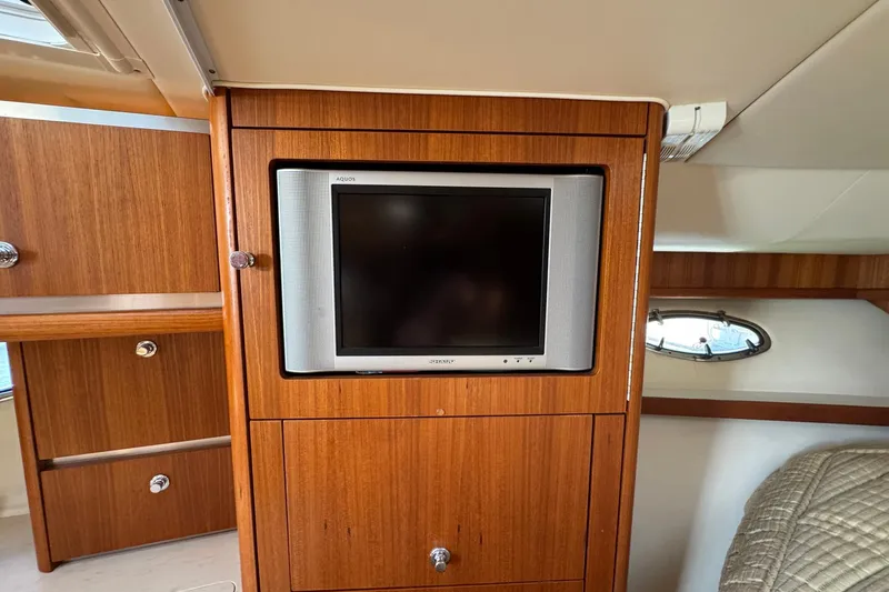 Lone Star Yacht Photos Pics 2005 Tiara Yachts 3200 Open interior with built-in TV and wooden cabinetry.