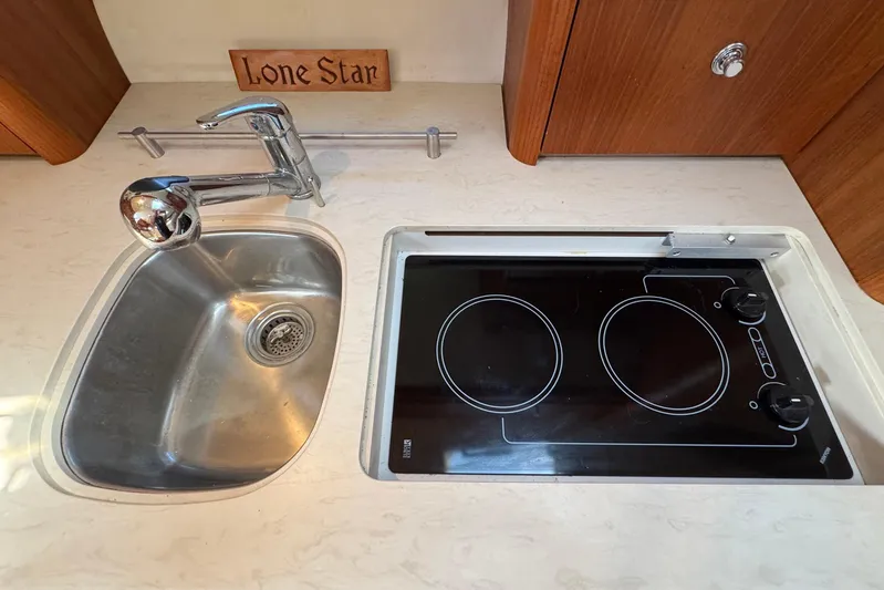 Lone Star Yacht Photos Pics Compact kitchen area in a 2005 Tiara Yachts 3200 Open, featuring a sink and stovetop.