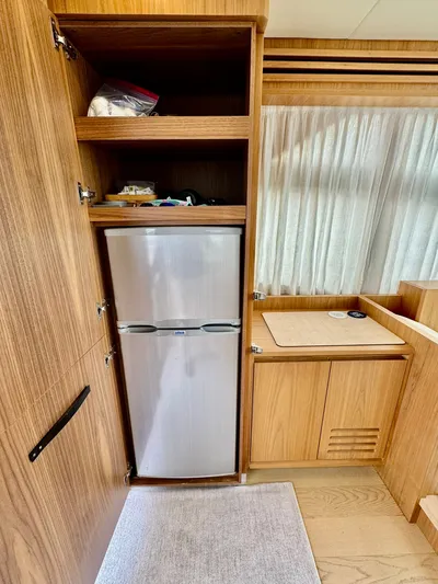 Yes Dear! Yacht Photos Pics Interior of a 2016 Absolute Sport Yacht featuring a compact kitchen with a fridge.