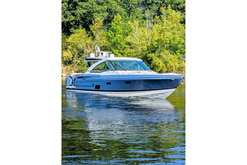  Yacht Photos Pics 2024 Formula 430 Super Sport Crossover boat on a serene lake with lush greenery.