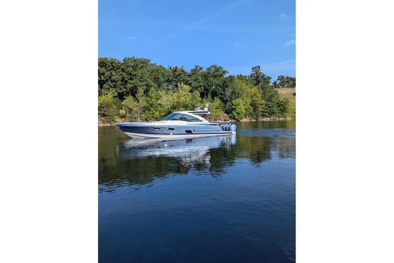  Yacht Photos Pics 2024 Formula 430 Super Sport Crossover boat cruising on a serene lake.