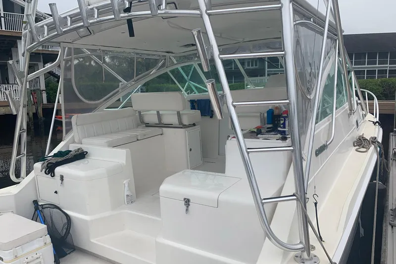 Dream Weaver Yacht Photos Pics 2002 Cabo 35 Express boat with white seating and stainless steel ladder in a marina.