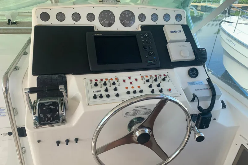 Dream Weaver Yacht Photos Pics Control panel of a 2002 Cabo 35 Express boat with navigation instruments and steering wheel.