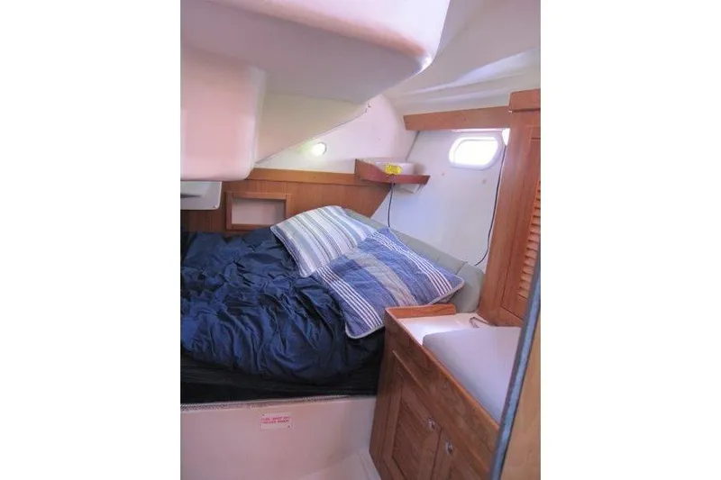 Sassy Cat Yacht Photos Pics Cozy cabin interior of 2004 Catalina 350 MkII sailboat with bed and wooden cabinetry.