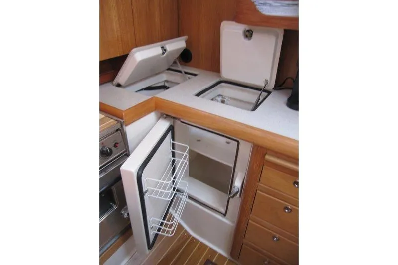 Sassy Cat Yacht Photos Pics 2004 Catalina 350 MkII yacht kitchen with open fridge and storage compartments.
