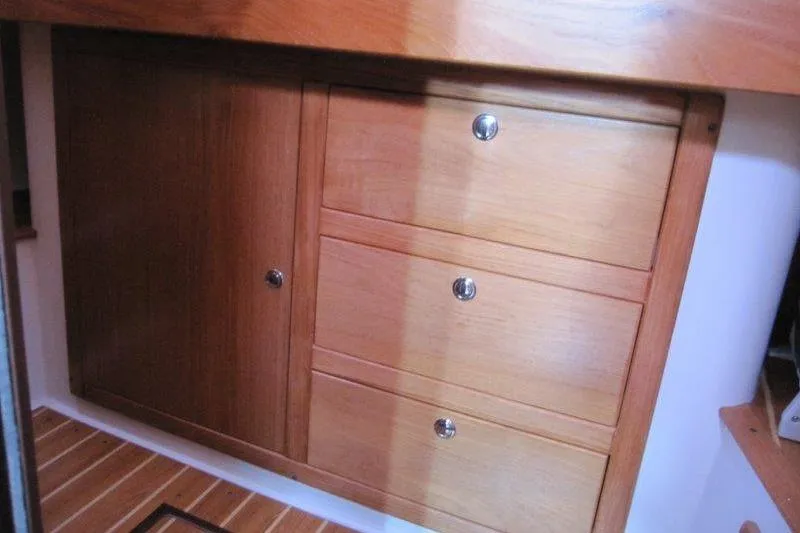 Sassy Cat Yacht Photos Pics Wooden cabinetry inside a 2004 Catalina 350 MkII sailboat, featuring drawers and a cabinet door.