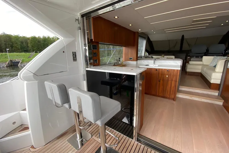  Yacht Photos Pics Luxurious interior of 2017 Sunseeker Manhattan 52 yacht with modern kitchen and seating area.