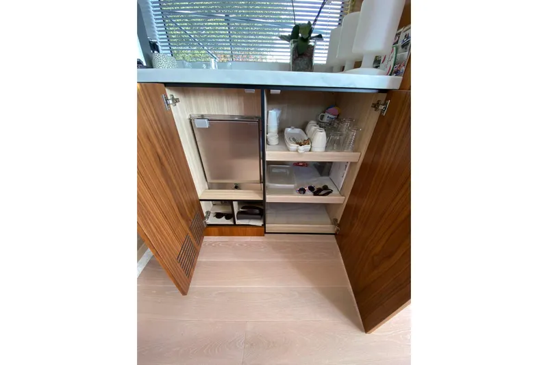  Yacht Photos Pics Open cabinet in 2017 Sunseeker Manhattan 52 yacht, showcasing organized kitchenware and storage.