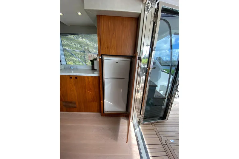  Yacht Photos Pics Interior view of 2017 Sunseeker Manhattan 52 yacht kitchen with wooden cabinetry and refrigerator.