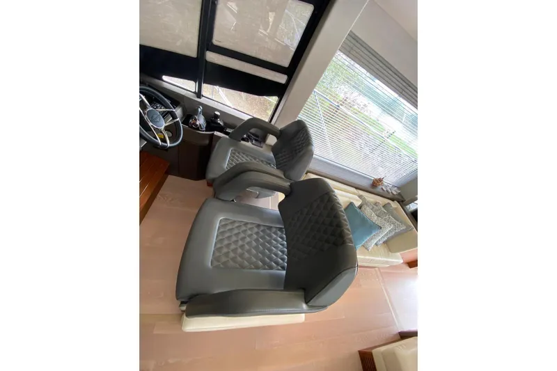  Yacht Photos Pics Luxurious interior seating of 2017 Sunseeker Manhattan 52 yacht, featuring plush, quilted chairs.