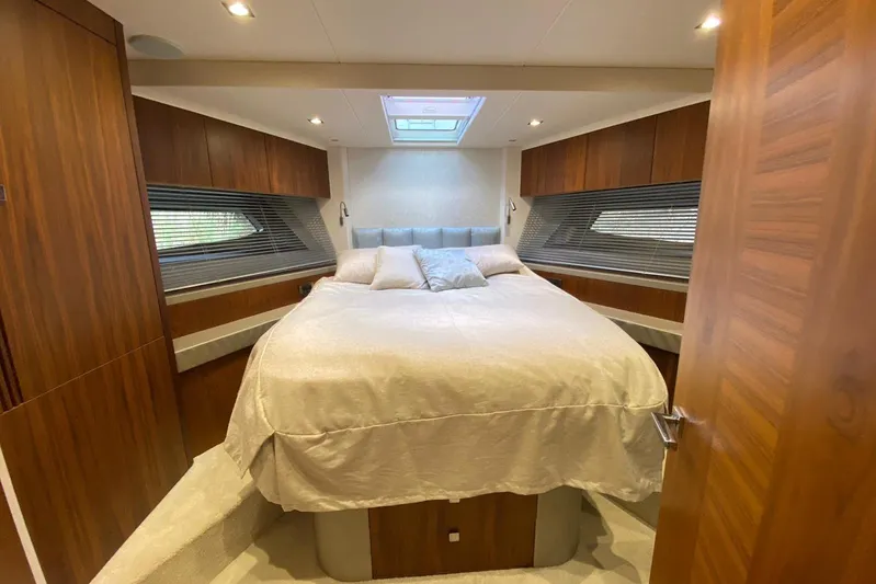  Yacht Photos Pics Luxurious bedroom interior of 2017 Sunseeker Manhattan 52 yacht with wood paneling and skylight.