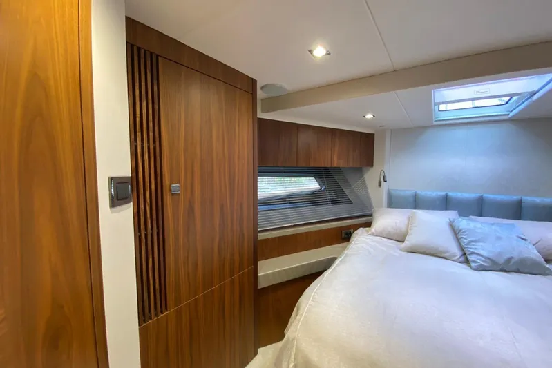  Yacht Photos Pics Luxurious bedroom interior of 2017 Sunseeker Manhattan 52 yacht with wood paneling and skylight.