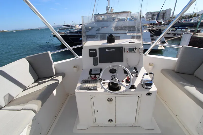 Pure Magic Yacht Photos Pics 2006 Island Hopper Sportfisher helm with Raymarine electronics, docked in a marina.