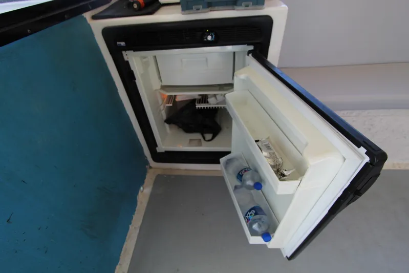 Pure Magic Yacht Photos Pics Open mini fridge on 2006 Island Hopper Sportfisher boat, containing water bottles and snacks.