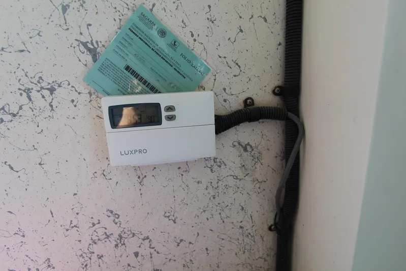 Pure Magic Yacht Photos Pics LuxPro thermostat on speckled wall with attached document, Island Hopper Sportfisher 2006.