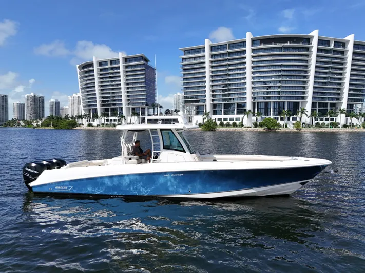  Yacht Photos Pics 2017 Boston Whaler 350 Outrage boat on water with modern buildings in background.