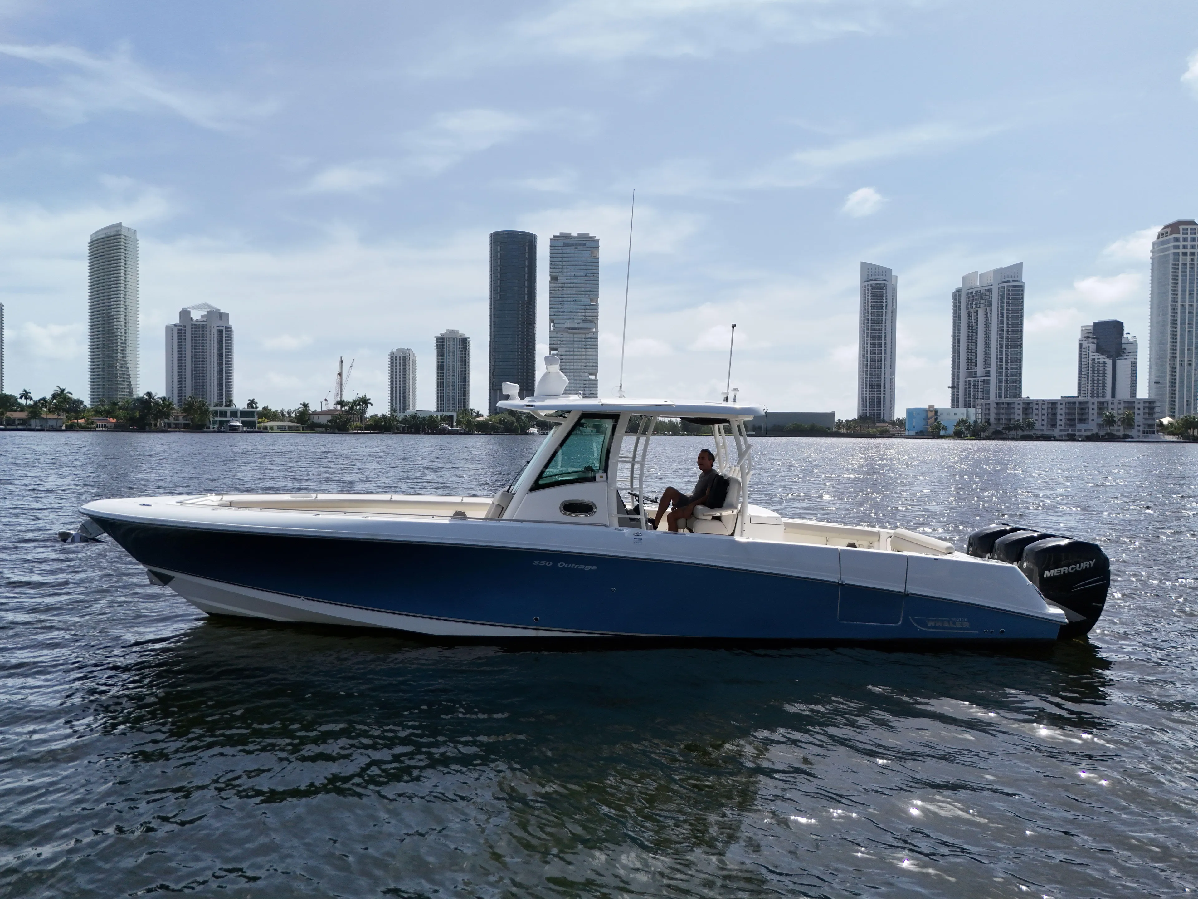  Yacht Photos Pics 2017 Boston Whaler 350 Outrage boat on water with city skyline in background.