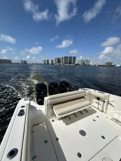  Yacht Photos Pics 2017 Boston Whaler 350 Outrage cruising on a sunny day with city skyline in background.