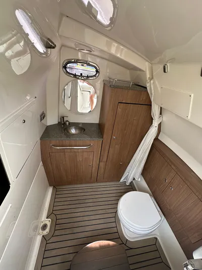  Yacht Photos Pics 2017 Boston Whaler 350 Outrage cabin with sink, toilet, and wood accents.